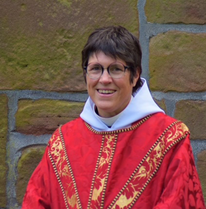 Alex Williams, the rector, in Sunday vestments, stood outside the church.