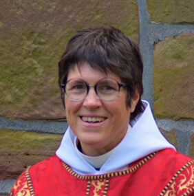 Alex Williams, the rector, in Sunday vestments, stood outside the church.